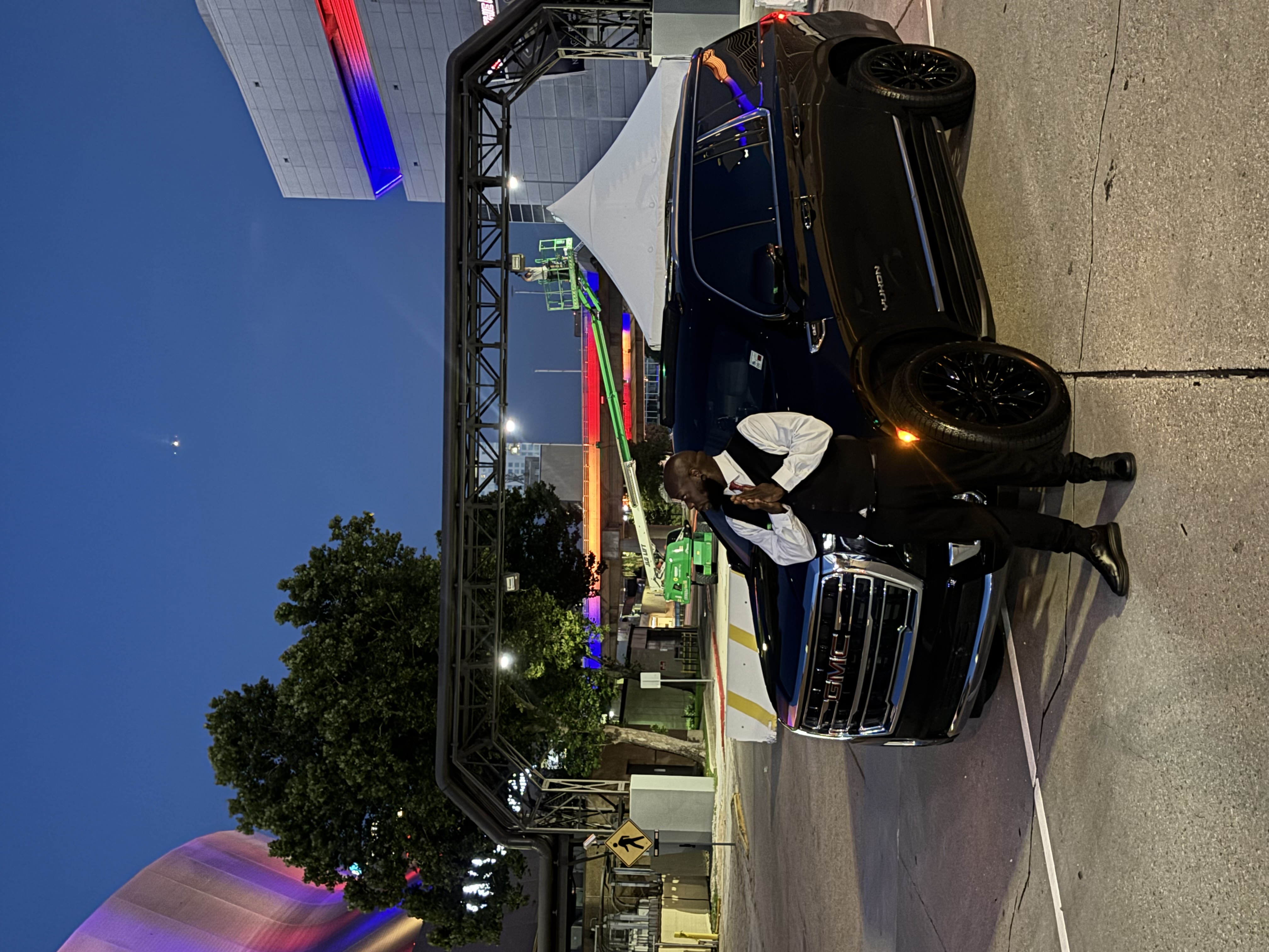 Professional chauffeur in formal attire beside a black luxury SUV